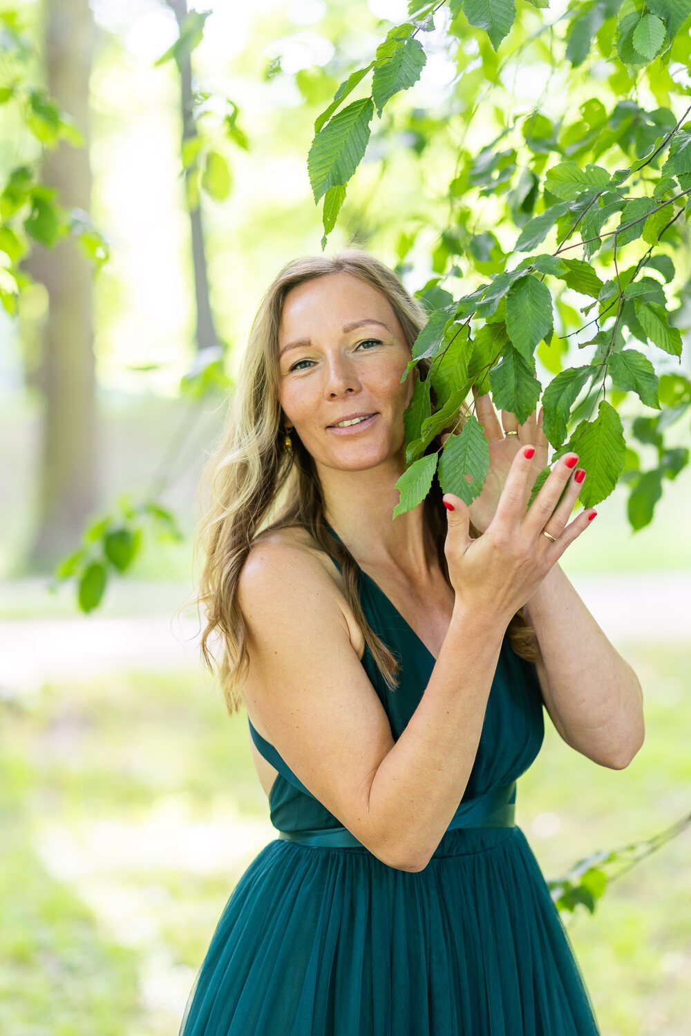 Dr. Julia König im sommergrünen Park, warmes Lächeln.